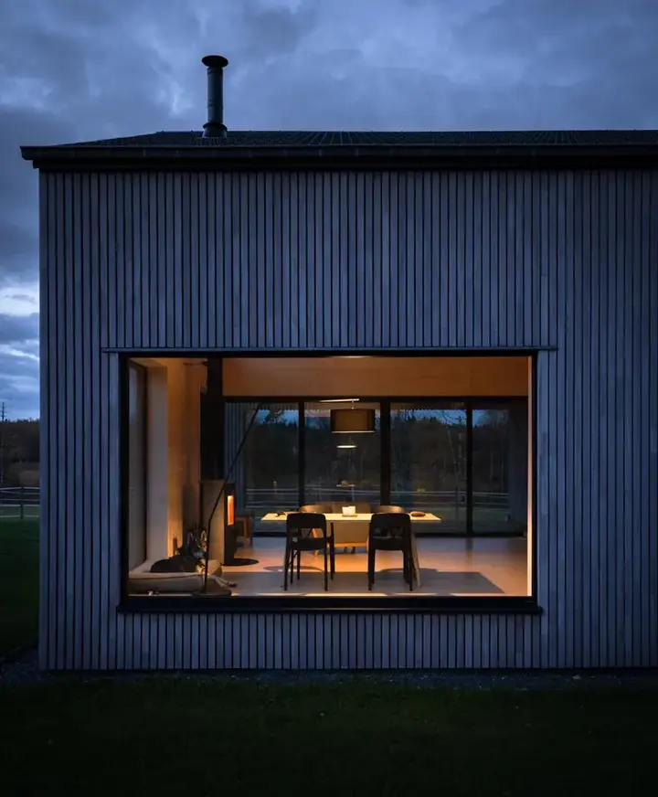 Façade noire de Metsä éclairée à la tombée de la nuit